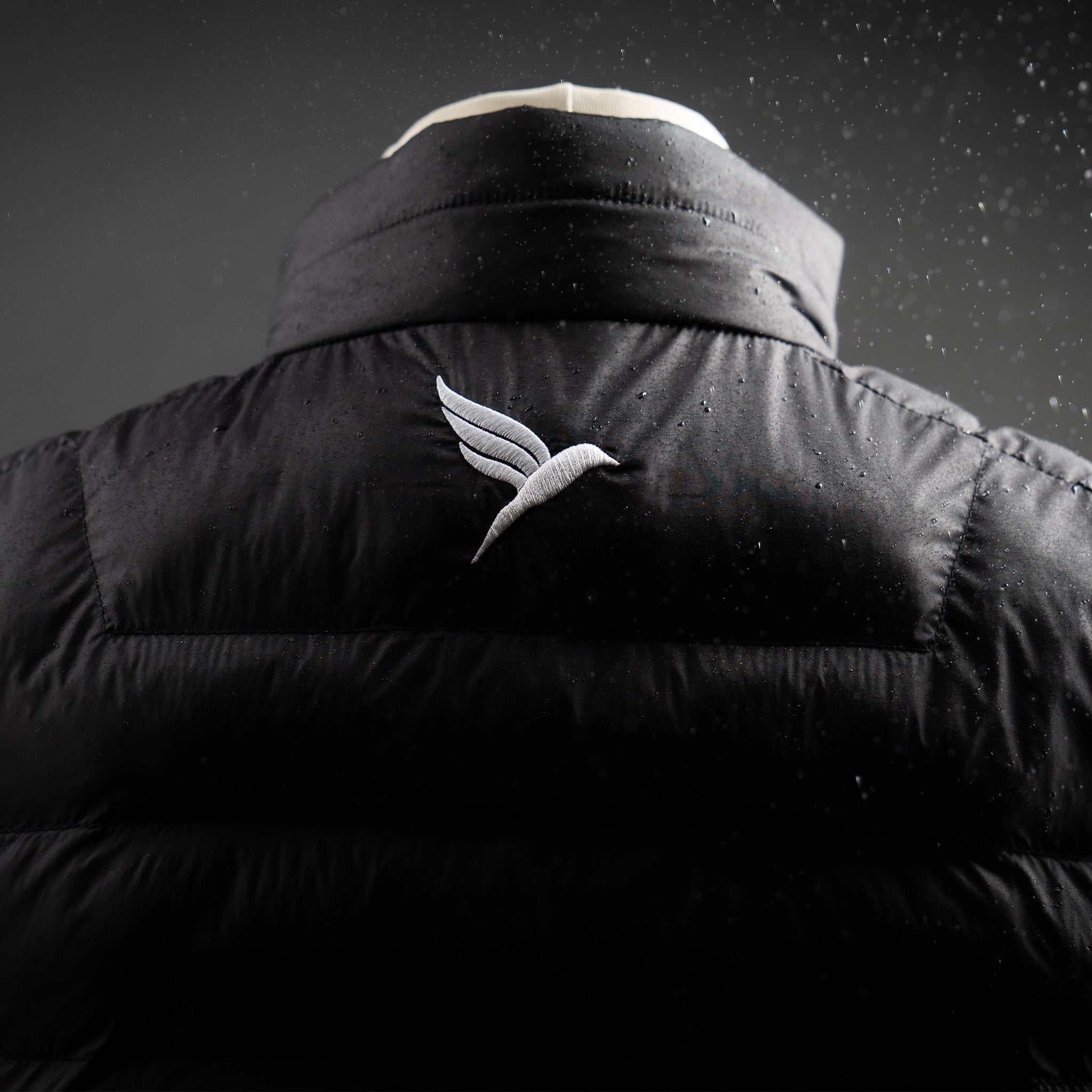 Black vest with a logo on the chest against a dark background
